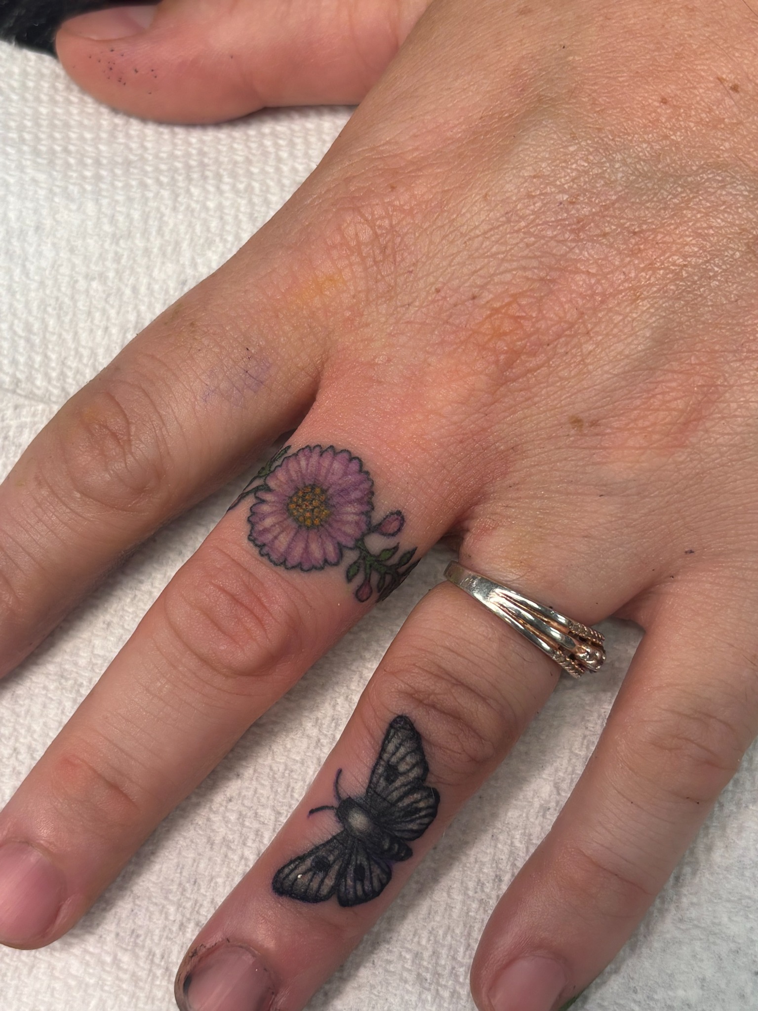 Flower and butterfly finger tattoos